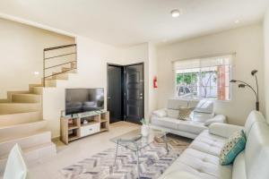 een woonkamer met een witte bank en een televisie bij Selvanova Coto 4B, Villa Flamingos 437F in Playa del Carmen