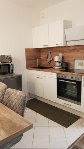een keuken met witte kasten en een fornuis bij Ferienwohnung Univers 2 in Bad Harzburg