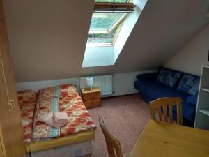 a attic room with a bed and a window at Guest House Kaskáda in Vrané nad Vltavou