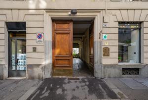 een gebouw met een houten deur op een straat bij Central Apartment in Turijn