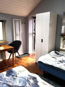 - une chambre avec 2 lits, un bureau et une table dans l'établissement Cosy cottage in a garden, à Ishøj