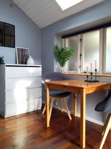 a dining room with a wooden table and a window at Cosy cottage in a garden in Ishøj