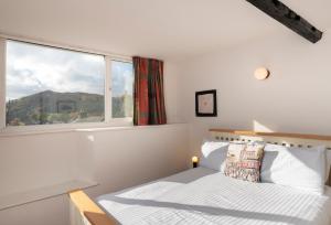 a white bedroom with a bed and a window at Look Far - 4BR - 2BA - Fabulous Views - Ambleside in Ambleside