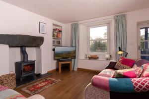 a living room with a fireplace and a tv at Look Far - 4BR - 2BA - Fabulous Views - Ambleside in Ambleside