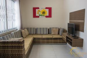 - un salon avec un canapé et une télévision dans l'établissement Sobrado aconchegante apenas 150 m do mar, à Guaratuba