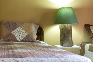 a lamp sitting on a table next to a bed at Las Calas Lodge in Bajos del Toro