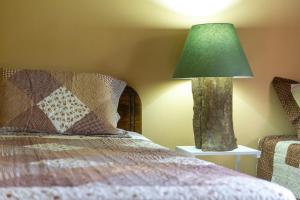 a lamp sitting on a table next to a bed at Calas Lodge in Bajos del Toro