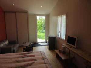 a bedroom with a bed and a television and a window at MARANATHA in Les Gonds