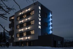 a building with a sign on it in the snow at SILVER hostel in Sheregesh