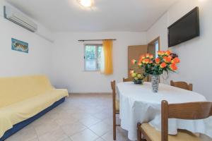 a living room with a table with a vase of flowers on it at Apartment Matea in Ubli