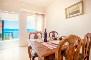 a dining room with a table and chairs and a window at Nissaki Suite Kalypso in Nisaki