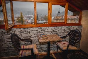 a table and two chairs in a room with a window at Curovac View in Sarajevo