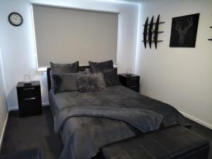 a bedroom with a large bed with two night stands at Jindabyne Guest House in Jindabyne