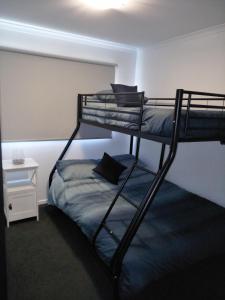 a room with two bunk beds and a bed at Jindabyne Guest House in Jindabyne