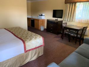Un pat sau paturi într-o cameră la Olive Tree Inn & Suites