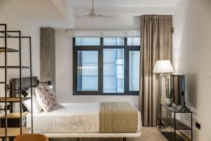 a bedroom with a bed and a large window at Goerlich by Alma Suites in Valencia