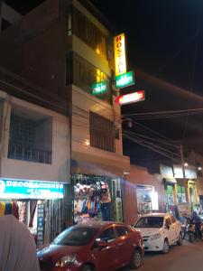dwa samochody zaparkowane na ulicy w nocy w obiekcie Hostal refugio's w mieście Ica