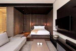 1 dormitorio con cama, sofá y TV en EAST Residences, en Hong Kong