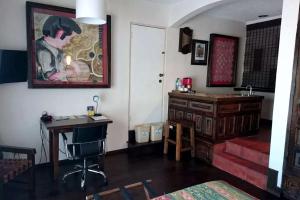 a living room with a desk and a painting on the wall at Best Western El Cid in Ensenada