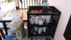 un estante con tazas y un secador de pelo. en Sythane Guesthouse, en Nongkhiaw