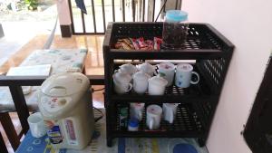 a shelf with cups and a hair dryer on it at Sythane Guesthouse in Nongkhiaw