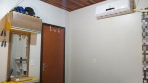 a room with a door and a heater on the wall at Hospedom Mazzoca 02 , WC compartilhado in Itapema