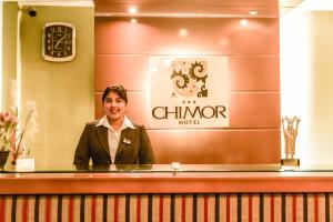 a woman standing behind a counter in a hotel at Hotel Chimor in Trujillo