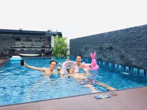 two women and a man in a swimming pool at The Seens Hotel in Krabi town