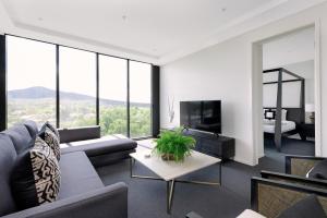 ein Wohnzimmer mit einem Sofa und einem Tisch in der Unterkunft Birch Apartments in the City in Canberra