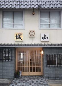 un edificio con letreros en la parte delantera en Shiroyama Ryokan, en Ikuma