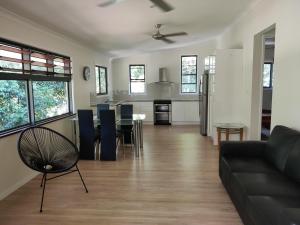 ein Wohnzimmer und eine Küche mit einem Sofa und einem Tisch in der Unterkunft Rainforest Retreat in Mission Beach