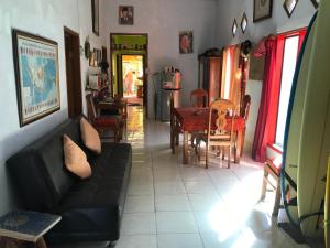 a living room with a couch and a table and chairs at Red Beach Homestay in Pasanggaran