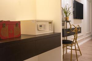 a microwave sitting on top of a counter with a chair at White Mansion Georgetown - Self Check-In in George Town