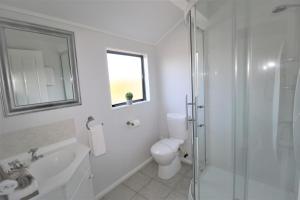 a bathroom with a toilet and a sink and a shower at AristaAir- Central City Townhouse in Rotorua