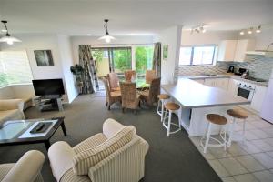 a kitchen and living room with chairs and a table at AristaAir- Central City Townhouse in Rotorua