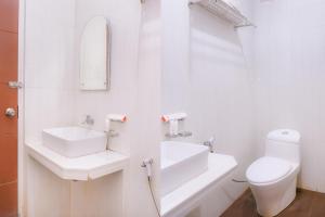 a white bathroom with a sink and a toilet at Super OYO Capital O 1630 Hotel Syariah Ring Road in Banda Aceh