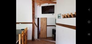 a room with a table and chairs and a tv at Cabañas De La Comarca in El Bolsón