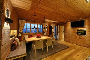 ein Esszimmer mit einem Tisch mit Stühlen und einem TV in der Unterkunft Villa Alpin in Kaltenbach