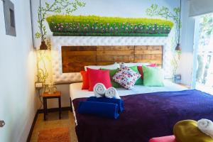 sypialnia z dużym łóżkiem z kolorowymi poduszkami w obiekcie Hotel boutique STAY Provenza w mieście Medellín