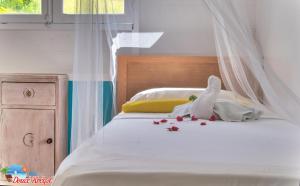 a bedroom with a white bed with flowers on it at Villa "Doucè Kréyol" in Le Marin