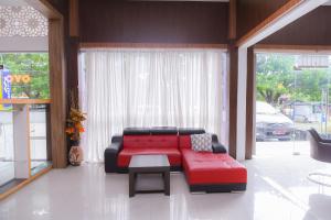バンダ・アチェにあるSuper OYO Capital O 1630 Hotel Syariah Ring Roadのリビングルーム(赤いソファ、テーブル付)