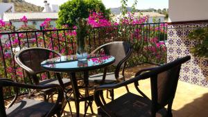 BermejoにあるCasa zona camino del reyのピンクの花が咲くバルコニー(テーブル、椅子付)