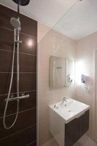 a bathroom with a sink and a shower at L'Espadon in Saint-Jean-de-Monts