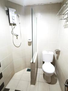 a bathroom with a toilet and a shower at Sunderland Motel in Kuah