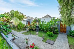 a garden with some plants and a house at Umah CinCin in Canggu