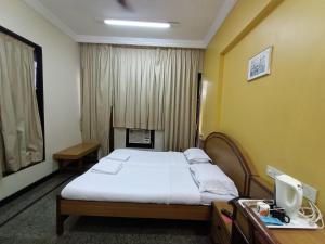 a hotel room with a bed and a desk at Hotel Park View, Mumbai in Mumbai