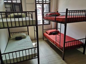 a room with three bunk beds and a window at Homey Hostel in Ipoh
