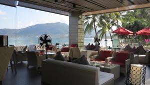 un restaurante con mesas y sillas y vistas al océano en 5* 3BR SUITE in Amari Phuket - Patong Beach en Patong Beach