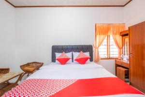 1 dormitorio con 1 cama con manta roja y blanca en Capital O 1541 Puri Cikole Asri, en Lembang