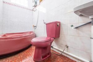 レンバンにあるCapital O 1541 Puri Cikole Asriのバスルーム(ピンクのトイレ、バスタブ付)